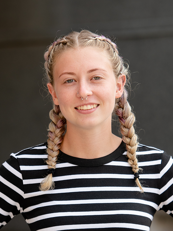 Arielle, smiling, wearing a black and white striped shirt